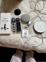 Full lot overview with key finder box and contents, Google Home Mini, charging pad