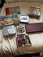 Overall view of eight boxed games and puzzle items on blanket
