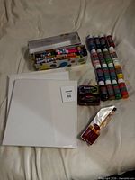 Full lot showing paints, canvases, markers, scratch notes, paintbrush