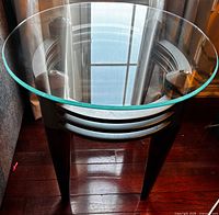 End table showing overall design with glass top, wood legs, metal ring