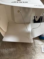 Interior of folded light box showing plastic panels and USB cable