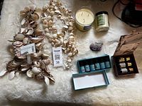 Overhead view of shell garlands, candles, essential oil sets and amethyst