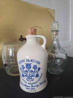 Overview of four barware pieces: Henry McKenna jug, Jack Daniel’s decanter, cut glass decanter, ribbed glass dispenser