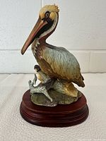 Full view of pelican figurine on wooden base