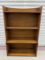 Front view of walnut Broyhill Sculptra bookcase showing three shelves