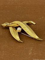 Front view showing leaf shape, brushed finish, and pearl