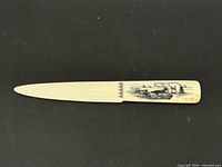 Full view of carved bone letter opener with etched polar bear artwork