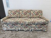 Front view of floral chenille sofa showing three cushions and skirt