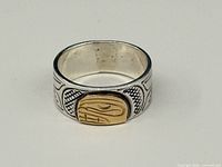 Front view of sterling band with gold Haida plaque