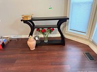 Front view of black-brown three-tier console table