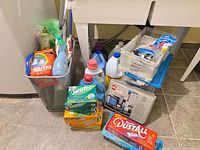 Full group of cleaning products in and around plastic bin