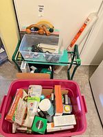 Overall lot showing garden kneeler, storage tote, clear bin and contents