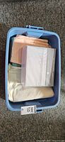 Blue tote containing packaged Gluckstein Home sheet set and folded fabrics