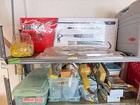 Shelf with JobMate set, jar of wall anchors, plastic bins, yellow jigsaw and assorted hardware