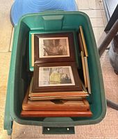 Top view of green bin holding stacked picture frames