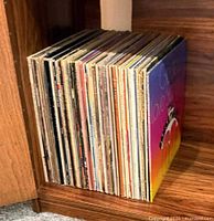 Stack of about 40 LPs on shelf, spines visible