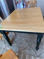 Full view of table showing butcher block top and black legs