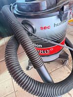 Front of Shop-Vac showing graphics, hose, caster base