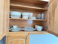 Cabinet view showing bowls, plates, glasses, indicating variety and counts