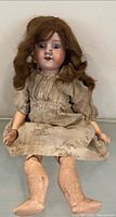 Full view of antique bisque doll seated
