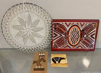 All four items grouped: lace hoop, geometric plaque, two sandstone tiles