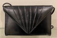 Front view of black faux leather shoulder purse showing flap design