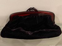 Front view of black velvet clutch with Bakelite frame