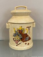 Full view of ceramic canister with lid showing speckled glaze and motif