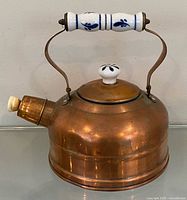 Full view of copper tea kettle showing porcelain handle and lid knob