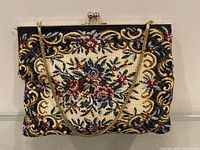 Front view of floral tapestry evening bag with chain and clasp