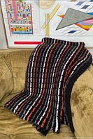 Blanket draped on sofa showing overall size and stripe pattern