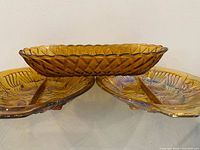 Front view of oblong pretzel pattern dish resting atop two Killarney divided dishes