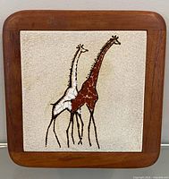 Front view of framed ceramic tile with giraffe design