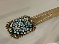 Close-up of bookmark head showing blue enamel flowers with crystal centers and gold-tone detailing
