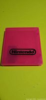 Front view of translucent pink Nintendo cartridge case