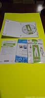 Open case showing Wii Fit Plus disc and three inserts laid out