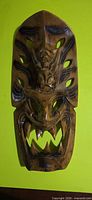 Front view of carved wooden mask showing overall design and condition