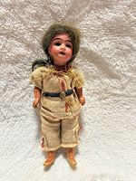Front view of 6-inch antique bisque head doll in original clothing