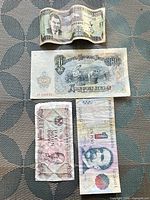 All four banknotes laid out on surface