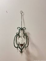 Full view of hanging beaded candle holder against wall