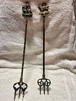 Full view of both brass pokers side by side
