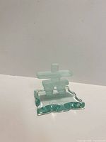 Front view of frosted glass inukshuk on wavy base showing overall form