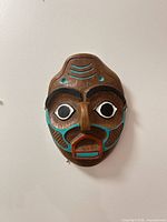 Front view of carved wooden mask with painted accents
