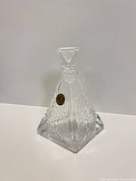 Full view of crystal perfume bottle front showing label and stopper
