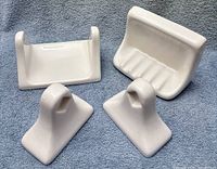Front view of one full set: soap dish, toilet-paper holder, two towel mounts