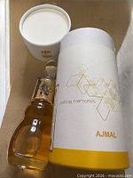 Bottle with outer cylindrical box and cup lid visible