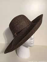 Left front profile of brown straw wide brim hat on mannequin head