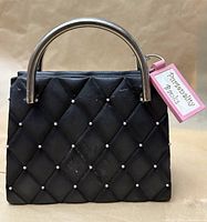 Front view showing quilted black ceramic body, rhinestone studs and metal handles