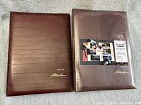 Front view of both albums showing faux leather covers; right album still in shrink wrap with retail insert