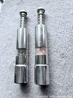 Front view of both chrome push-style mills showing acrylic windows and spring tops